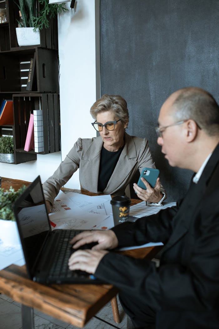 Man in Black Suit Jacket Sitting Beside Woman in Gray Long Sleeve Shirt